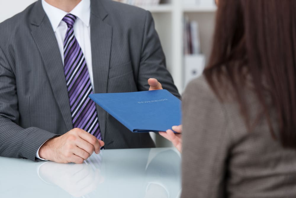 woman handing man a folder