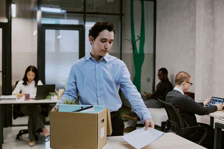 employee packing up his desk and putting personal things in a box