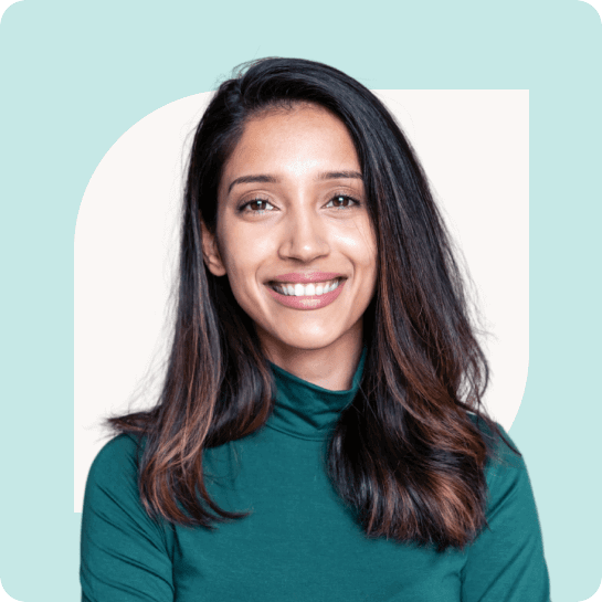 A person with long brown hair in a teal top is smiling against a light teal and cream background.